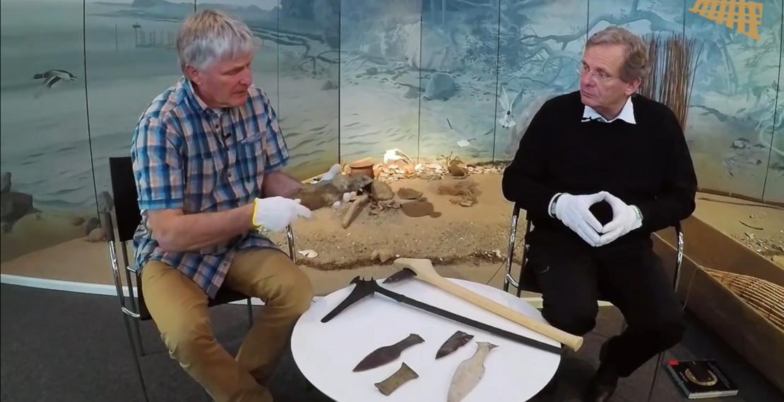 Screenshot von Prof. Dr. Dr. h.c. Claus von Carnap-Bornheim und Dr. Sönke Hartz, die in der Reihe "Archäologie zu zweit" archäologische Fundstücke erklären. 